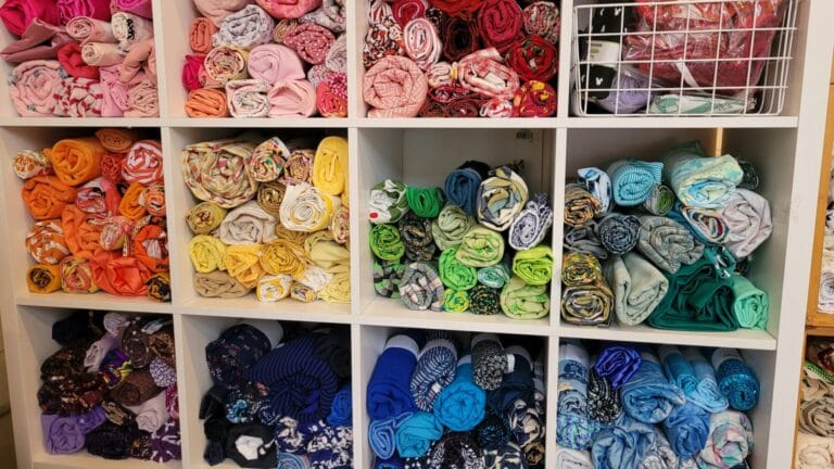 Colorful rolled cloths on shelves